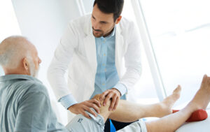 Medical professional examining patient's knee during physical therapy session