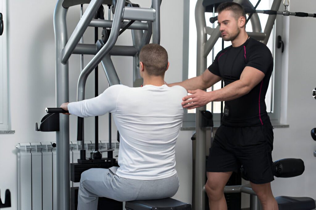 Physical therapist guiding patient through proper form on weight machine during post-surgery rehabilitation