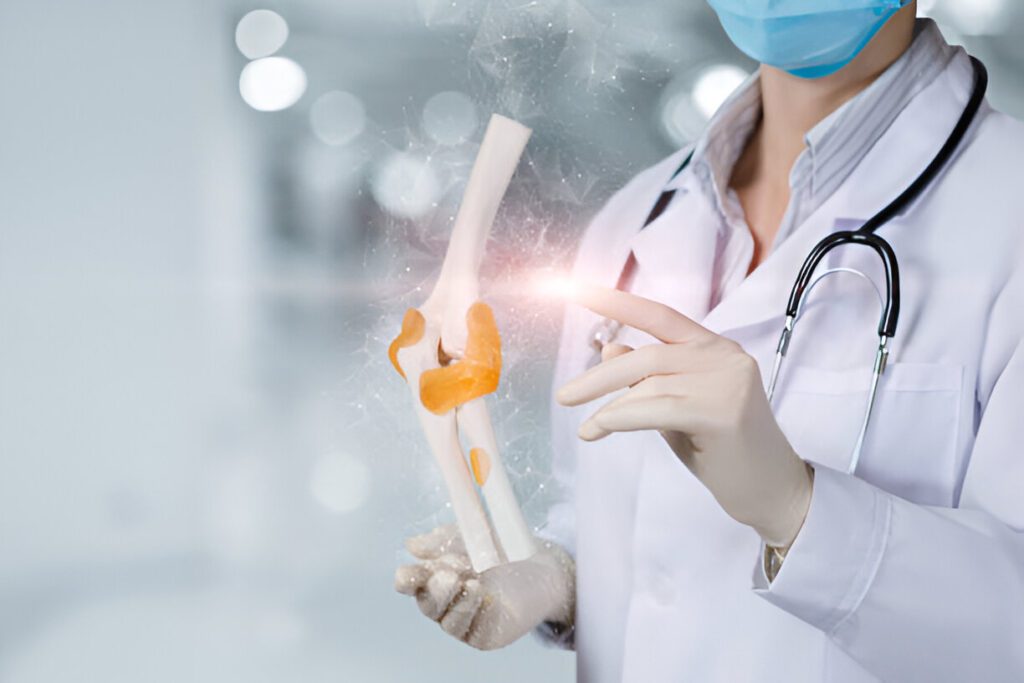 Medical professional in white coat and surgical mask examining anatomical knee joint model with illuminated surgical planning overlay