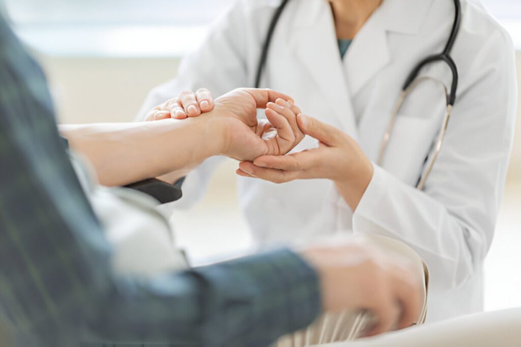 Doctor in white coat performing detailed hand examination for reconstruction evaluation