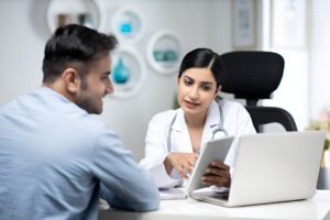 Doctor consulting with a patient about recovery and outcomes after synovectomy surgery.